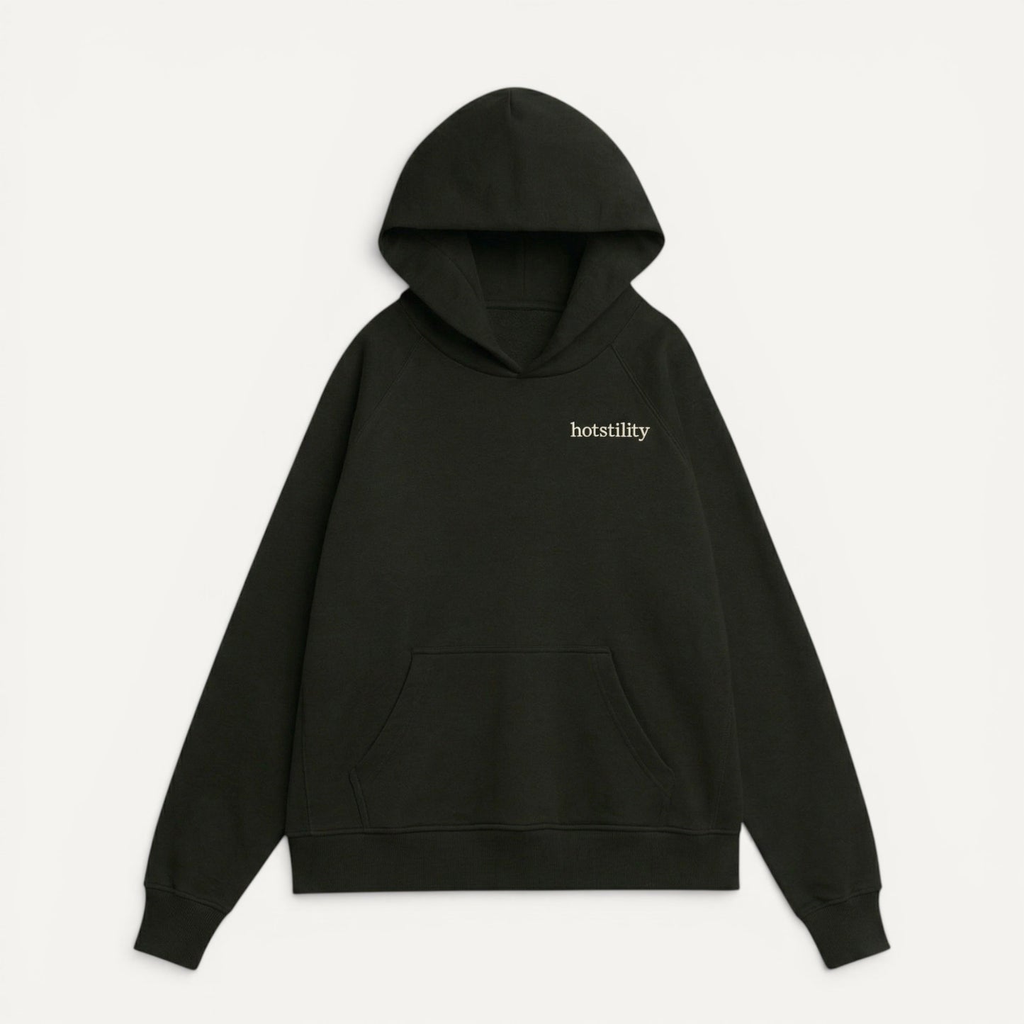 front view of black oversized organic french terry hoodie with "hotstility" embroidered text on chest, relaxed fit with structured silhouette